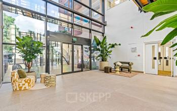 Ruime ingang met moderne zitruimte en veel natuurlijk licht in het kantoorpand op Maanlander 43, Amersfoort Calveen. Ideaal voor kantoorruimte huren.