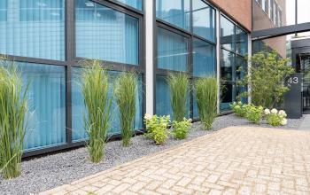Exterieur van een modern kantoorpand op Maanlander 43 in Amersfoort Calveen, met goed onderhouden groenvoorzieningen voor de ramen. Ideaal voor wie kantoorruimte wil huren in een zakelijke omgeving.