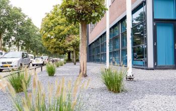 Buitenzijde van een modern kantoorpand op Maanlander 43 in Amersfoort Calveen, met goed onderhouden groen en grote glazen ramen. Geschikt om een kantoorruimte te huren.