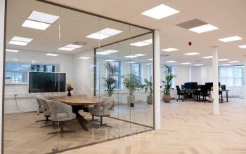 Ruime, moderne kantoorruimte te huur op Maanlander 43, Amersfoort Calveen met glazen vergaderruimte en open werkplekken. Strak interieur met veel lichtinval en moderne meubels.