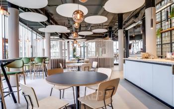 Moderne kantoorruimte huren met stijlvolle inrichting op Maanlander 47 in Amersfoort Calveen, voorzien van comfortabele zitplekken en een speels ontwerp met unieke verlichting in een open vloerplan.