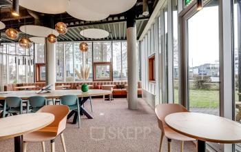 Moderne kantoorruimte in Amersfoort Calveen met grote ramen, stijlvolle meubilering en veel natuurlijk licht; ideaal om te huren voor creatieve werksessies.