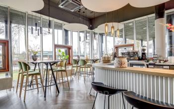 Kantoorruimte op Maanlander 47 in Amersfoort Calveen, met moderne bar en hoge tafels, grote ramen voor natuurlijk licht. Ideale plek om een kantoor te huren.