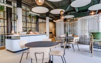 Moderne, goed verlichte kantine in een kantoorpand op Maanlander 47, Amersfoort Calveen. Stijlvolle tafels en stoelen, met een uitnodigende sfeer voor een ontspannen lunch of informele bijeenkomst. Ideaal voor kantoorruimte huren.