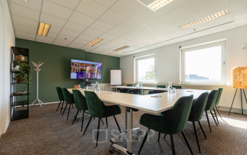 Vergaderzaal in kantoorpand op Stationsplein 49, Amersfoort Centraal Station met groene stoelen en conferentietafel. Ideaal voor kantoorruimte huren in een centraal gelegen kantoor.