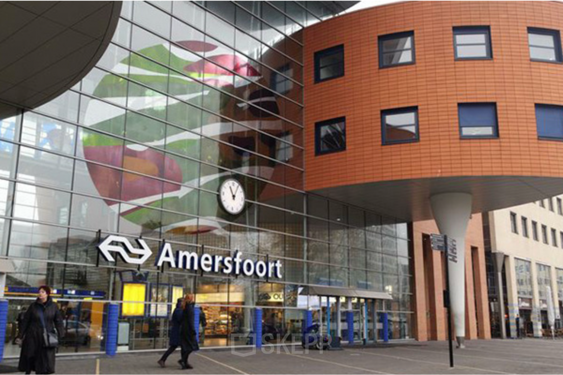 Buitenkant van het moderne kantoorpand op Stationsplein 49, onderdeel van Amersfoort Centraal Station, met opvallende architectuur en een grote glazen gevel.
