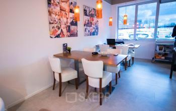 Gezellige kantoorruimte te huur aan de Stadsring 157-165 in Amersfoort Centrum, met moderne verlichting, houten tafels en comfortabele stoelen, perfect voor vergaderingen.