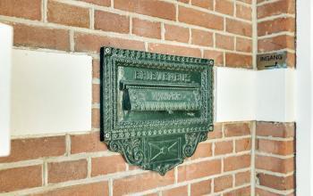 Historisch details van stijlvol kantoorpand gelegen aan Stadsring 248-250 in Amersfoort Centrum, met een klassieke, groene brievenbus ingebouwd in een bakstenen muur.