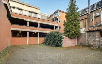 Parkeerplaats voor kantoorpand op Stadsring 248-250, Amersfoort Centrum, omgeven door rode bakstenen muren met veel groen. Beschikbaar voor kantoorruimte huren.