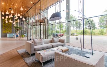 Lobby met moderne inrichting, zitgedeelte met banken en tafels in kantoorpand op Databankweg 26, Amersfoort De Hoef.