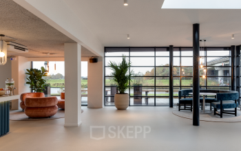 Moderne kantoorruimte met grote ramen, veel lichtinval en stijlvolle zitjes met planten. Gelegen aan Vanadiumweg 11 in Amersfoort Isselt.