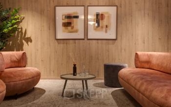 Gezellige lounge in kantoorpand op Vanadiumweg 11, Amersfoort Isselt met twee comfortabele banken en moderne kunst aan de muur, ideaal voor informeel overleg of ontspanning tijdens werkuren.