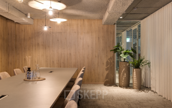 Moderne vergaderruimte in het kantoorpand op Vanadiumweg 11, Amersfoort Isselt, met een lange tafel en stijlvolle verlichting. Kantoorruimte huren met een strakke, professionele uitstraling.