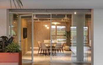Vergaderruimte in een modern kantoorpand gelegen aan Vanadiumweg 11 in Amersfoort Isselt. Houten muren, glazen wanden, en comfortabele stoelen nodigen uit om bijeenkomsten te houden.