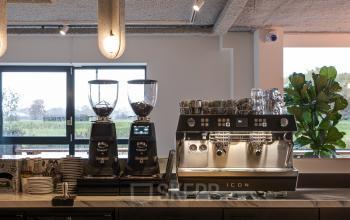 Moderne pantry in kantoorpand op Vanadiumweg 11, Amersfoort Isselt, voorzien van espressomachines en frisdrankkoelkast.