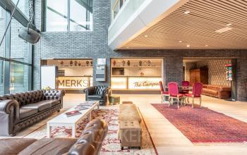 Interieur van het kantoorpand aan Prof. W.H. Keesomlaan 12 in Amstelveen met een gezellige zithoek, banken, en een balie.