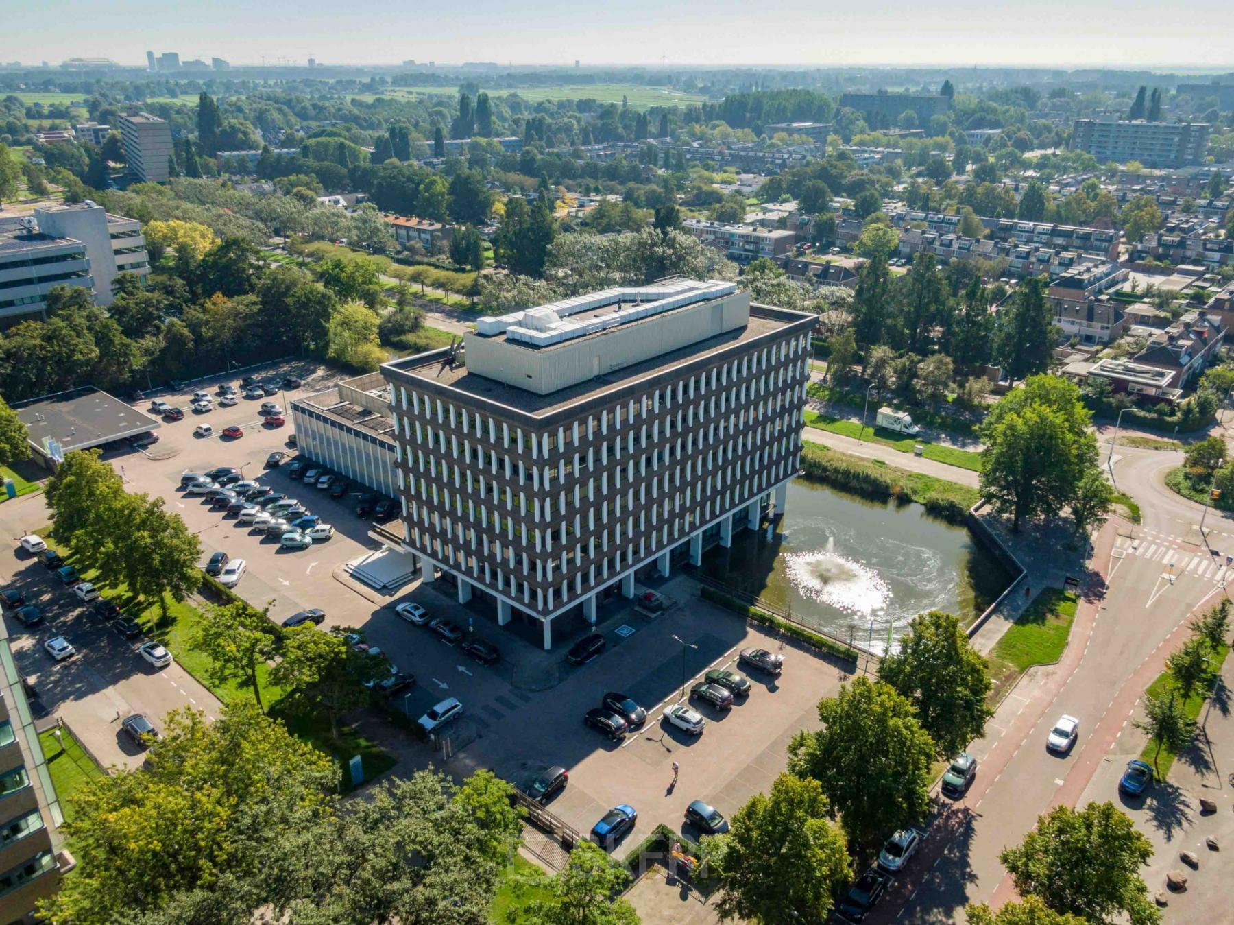 Exterieur van het kantoorpand aan Professor E.M. Meijerslaan 1 in Amstelveen, omgeven door groene bomen en een parkeerplaats.