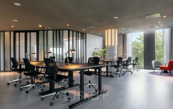 Kantoorruimte huren aan de Amstelvlietstraat 4 in Amsterdam Amstel Business Park. Moderne kantoorpand met ruime werkplekken, bureaus en stoelen onder zachte verlichting met ramen voor natuurlijke lichtinval.