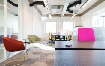Moderne kantoorruimte te huur op Willem Fenengastraat 2, Amsterdam Amstel Business Park, met kleurrijke stoelen en bureaus, voldoende daglicht en stijlvol interieur.