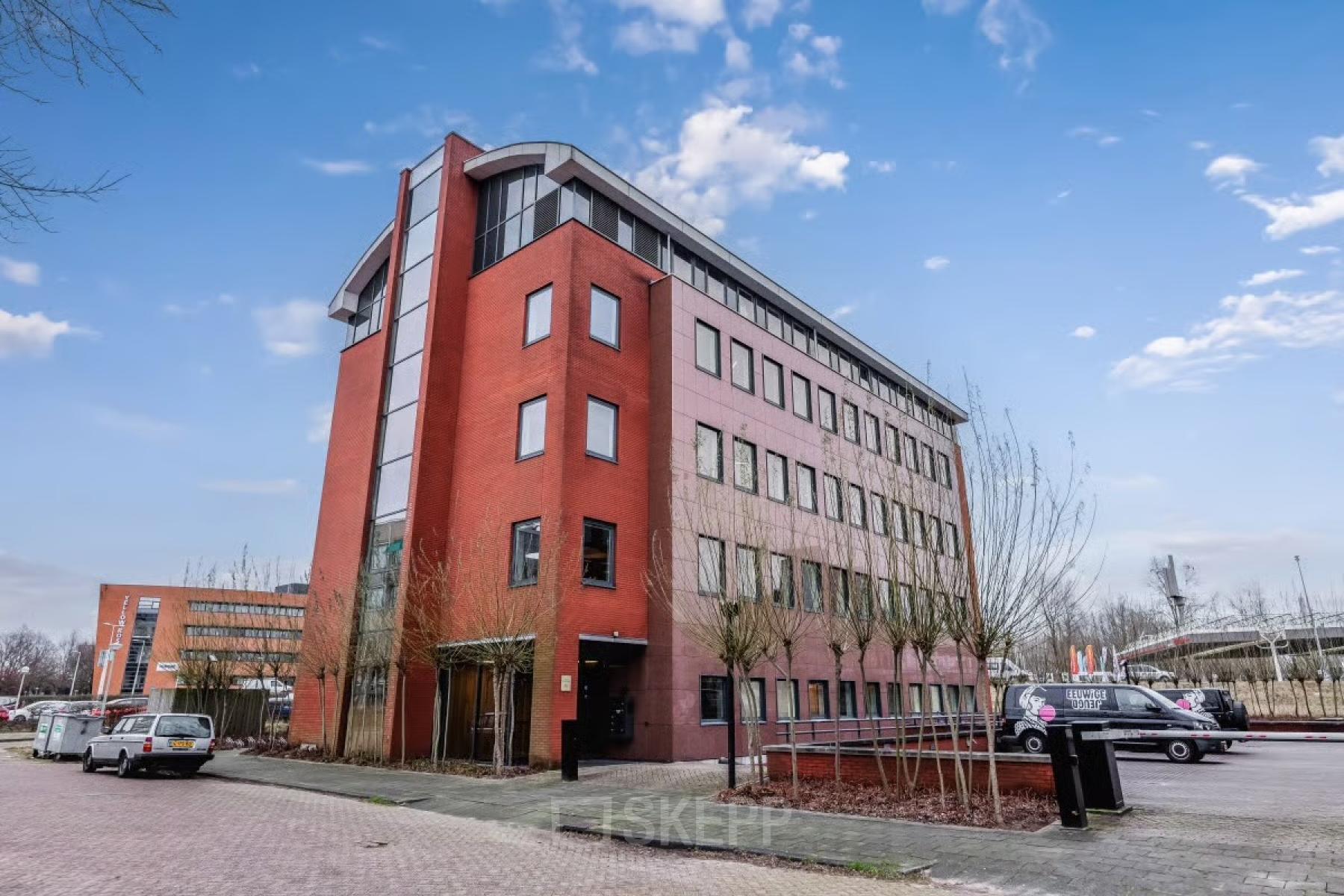 Buitenzijde van een modern kantoorpand aan de H.J.E. Wenckebachweg 90-108, Amsterdam Amstel Business Park. Geschikt voor kantoorruimte huren met meerdere verdiepingen en een eigentijds ontwerp.