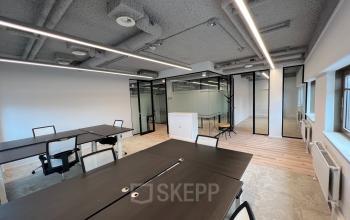 Kantoorruimte huren bij Joop Geesinkweg 601, Amsterdam Amstel Business Park. Modern ingerichte werkruimte met bureaus, stoelen en glazen wanden. Lichtinval via grote ramen, met uitzicht op arbeidsruimtes.