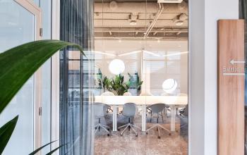 Moderne vergaderruimte in het kantoorpand aan de Joop Geesinkweg 601, Amsterdam Amstel Business Park, met grote tafel en stoelen, planten en glazen wanden.