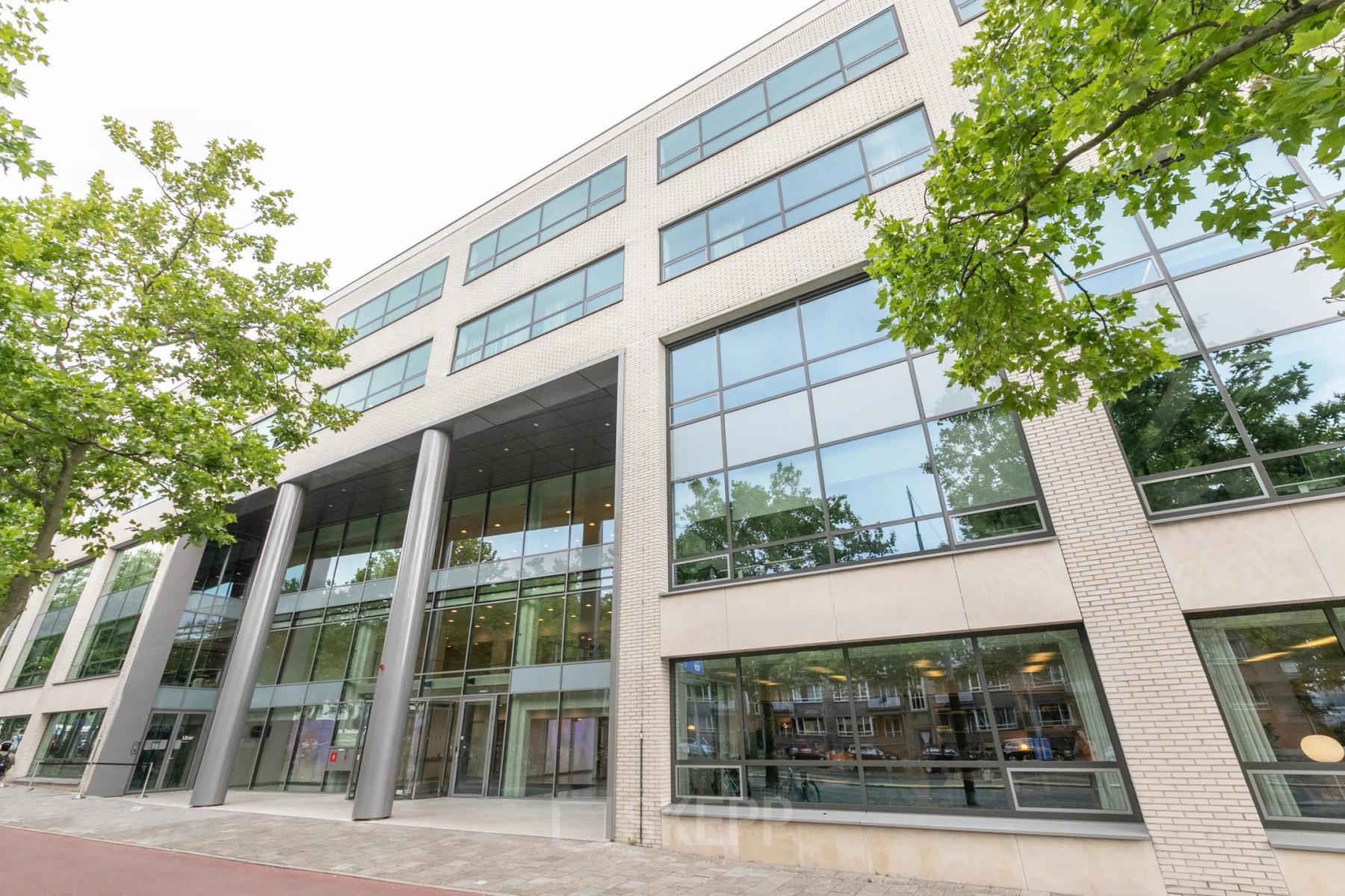 Moderne kantoorruimte om te huren aan Mr. Treublaan 7 in Amsterdam Amstel met grote glazen gevel, perfect passend in een inspirerende kantoorpand omgeving.