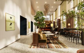 Binnen in het kantoorpand aan Willem Fenengastraat 16 in Amsterdam Amstel, moderne inrichting met houten tafels, banken en stijlvolle verlichting, perfect voor huur als werk- of ontmoetingsruimte.