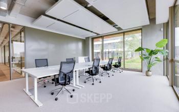 Heldere kantoorruimte op Willem Fenengastraat 16, Amsterdam Amstel, met moderne werkplekken, grote ramen en planten. Ideaal om kantoorruimte te huren voor een productieve werkomgeving.