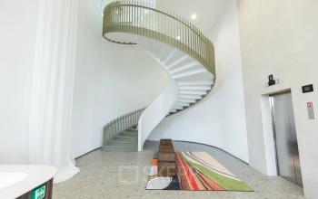 Kantoorpand in Amsterdam Amstel met moderne, gewelfde trappen en speels gekleurde vloerbedekking. Geschikt voor kantoorruimte huren op Willem Fenengastraat 16.