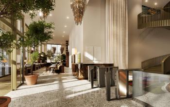 Open en lichte entree van kantoorpand op Willem Fenengastraat 16, Amsterdam Amstel. De ruimte heeft een sierlijk trappenhuis en moderne toegangspoorten. Groen en elegant design benadrukken de professionaliteit van de werkomgeving.