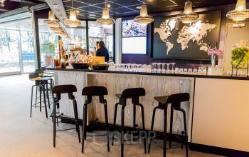 Moderne kantoorruimte op Prins Bernhardplein 200, Amsterdam Amstel, met een stijlvolle bar en wereldkaart als decor. Geschikt voor zakelijke bijeenkomsten en huur van kantoren.