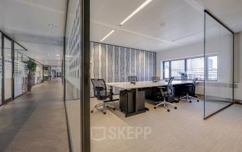 Lichte kantoorruimte op Prins Bernhardplein 200 te Amsterdam Amstel, ingericht met moderne kantoormeubelen en voorzien van grote ramen waardoor natuurlijk licht binnenvalt.