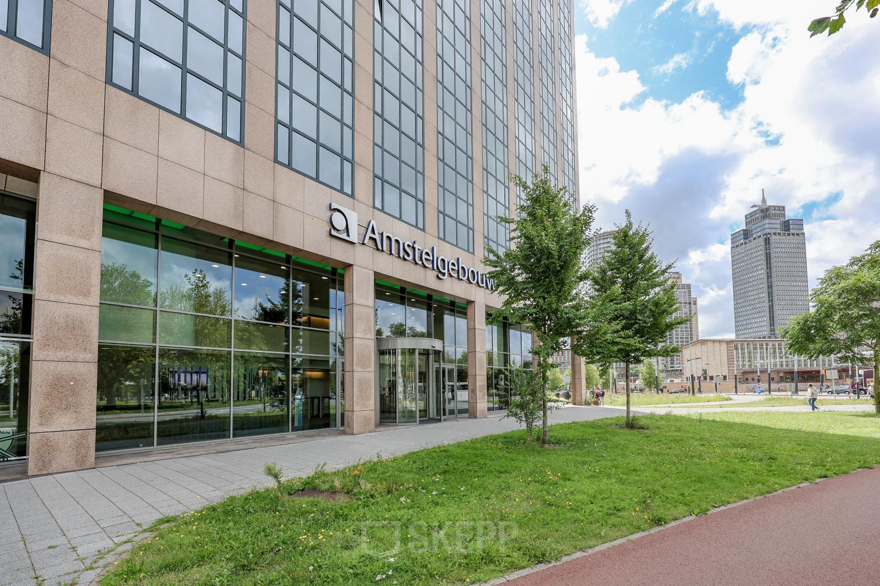 Kantoorpand aan Prins Bernhardplein 200 in Amsterdam Amstel, met moderne gevel en grootse ramen. Ideale locatie voor kantoorruimte huren in het Amstelgebouw. Gelegen in een groene omgeving.