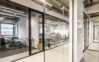 Moderne kantoorruimte huren op Wibautstraat 135, Amsterdam Amstel; glazen wanden, werkplekken en stoelen aanwezig