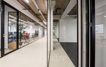 Modern ingerichte kantoorruimte met glazen wanden in kantoorpand aan de Wibautstraat 135, Amsterdam Amstel.