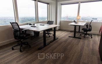 Kantoorruimte huren met uitzicht in het kantoorpand aan Amstelplein 8, Amsterdam Amstel, met twee moderne bureaus en stoelen.