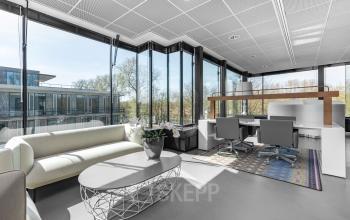 Modern ingericht kantoorpand in Amsterdam Buitenveldert met comfortabele zithoek en voldoende daglicht bij De Cuserstraat 93.