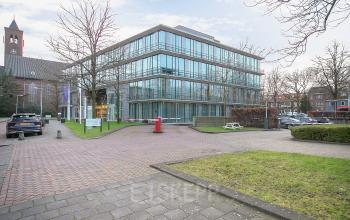 Modern kantoorpand aan De Cuserstraat 91 in Amsterdam Buitenveldert, omringd door een groene omgeving en parkeerplaatsen. Ideaal om kantoorruimte te huren.