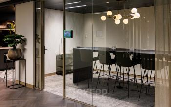 Moderne kantoorpand in Amsterdam Buitenveldert met stijlvol ingerichte ruimte, inclusief hoge tafel en stoelen, perfect voor vergaderingen. Ideaal voor wie kantoorruimte wil huren op Walborg 2A.