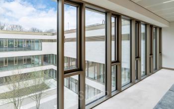 Kantoorruimte huren aan Walborg 2A in Amsterdam Buitenveldert met uitzicht op een binnenplaats en grote, moderne ramen.