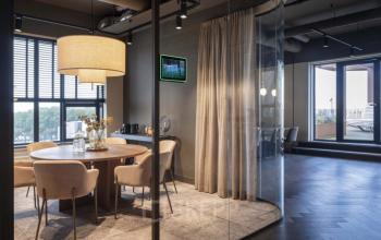 Moderne vergaderruimte met glazen wanden op Walborg 2A, Amsterdam Buitenveldert. Een grote ronde tafel met stoelen en stijlvolle verlichting maakt het ideaal voor kantoorruimte huren.