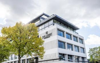 Kantoorpand aan Zwaansvliet 1 in Amsterdam Buitenveldert, modern gebouw met grote ramen en een boom aan de voorzijde. Geschikt voor kantoorruimte huren.