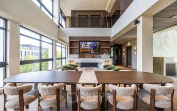 Moderne kantoorruimte in Amsterdam Buitenveldert met een grote tafel en comfortabele stoelen, ideaal om te huren als werkruimte. Het interieur is ruim en licht met uitzicht over de stad.