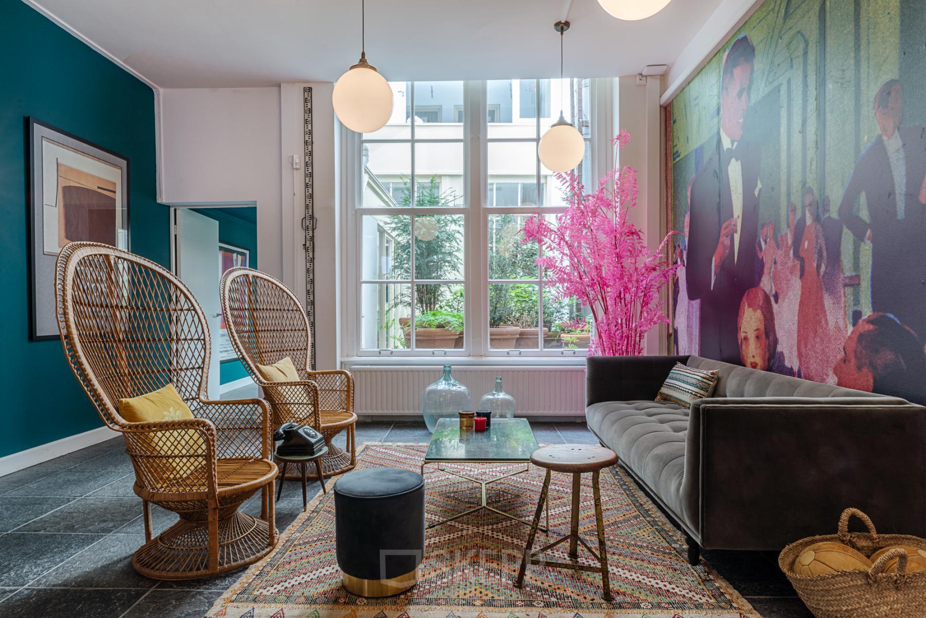 Stijlvolle kantoorruimte huren in Amsterdam Centrum, gelegen aan Nieuwezijds Voorburgwal 296-298, met comfortabele zitplekken, kleurrijke inrichting en grote ramen voor veel natuurlijk licht.