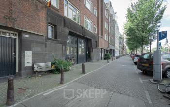 Kantoorpand Oudeschans 21 in Amsterdam Centrum, buitenaanzicht van gebouw met geparkeerde auto's en fietsen.