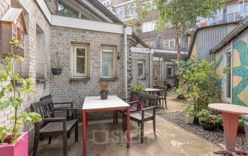 Gezellige binnenplaats bij kantoorpand aan Oudeschans 21 in Amsterdam Centrum met terrasmeubilair en planten.