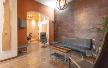 Moderne kantoorruimte met stijlvolle loungehoek op Oudeschans 21, geschikt voor creatief ondernemen in Amsterdam Centrum.