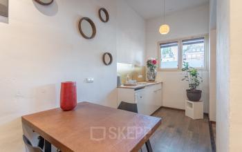 Moderne kantoorruimte te huur aan Oudeschans 21 in Amsterdam Centrum, uitgerust met een houten tafel en comfortabele stoelen.