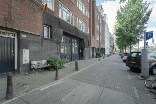 Kantoorpand Oudeschans 21 in Amsterdam Centrum, buitenaanzicht van gebouw met geparkeerde auto's en fietsen.